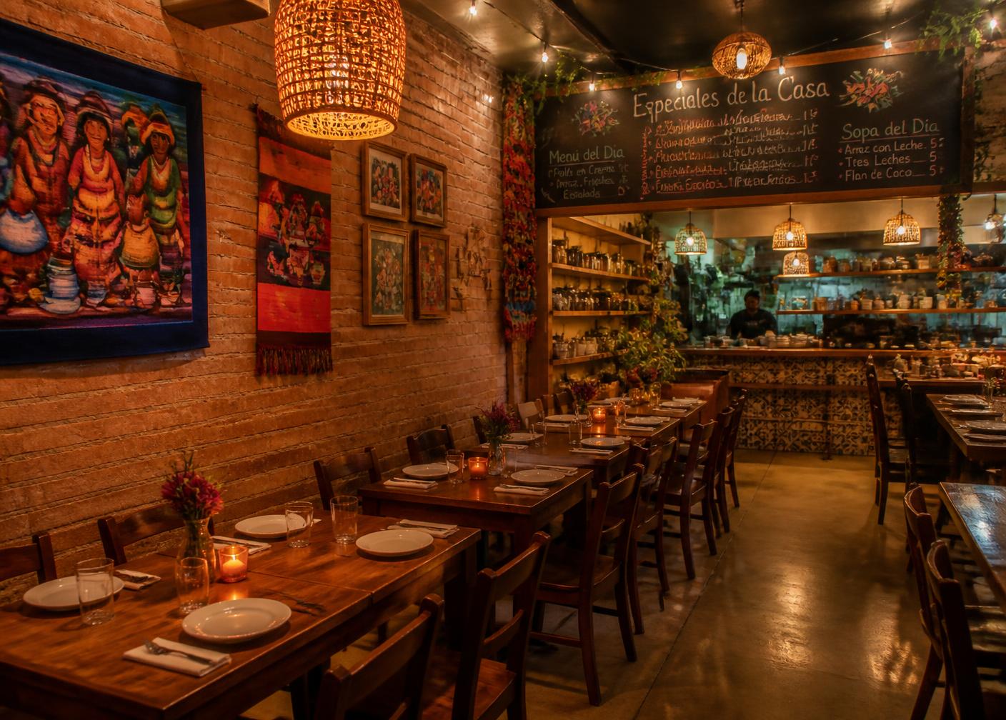 Salle à manger chaleureuse du Restaurant El Amigo avec tables en bois et art folklorique
